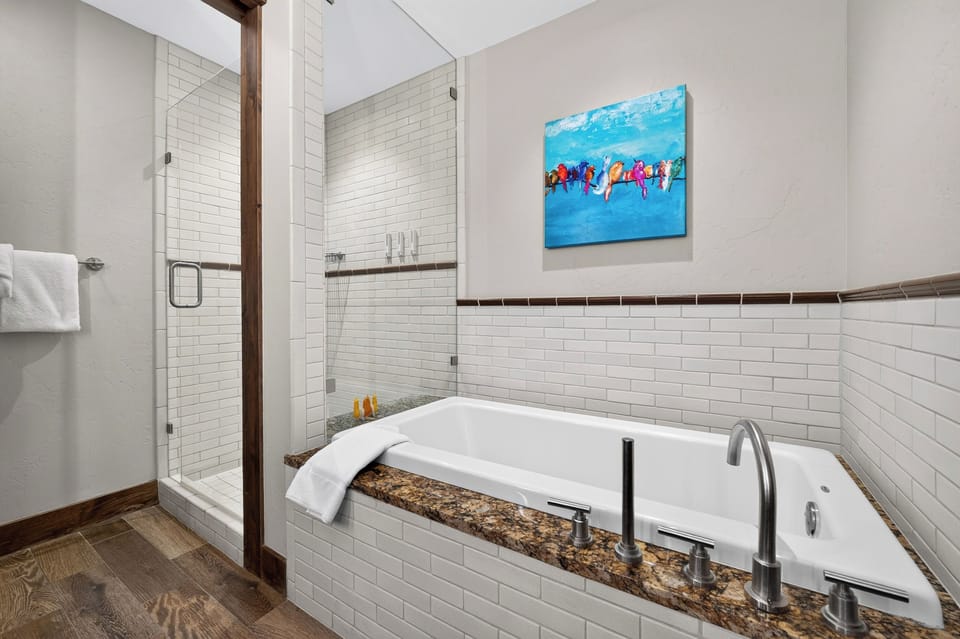 Unwind in the deep soaking tub, with a glass-enclosed shower alongside.