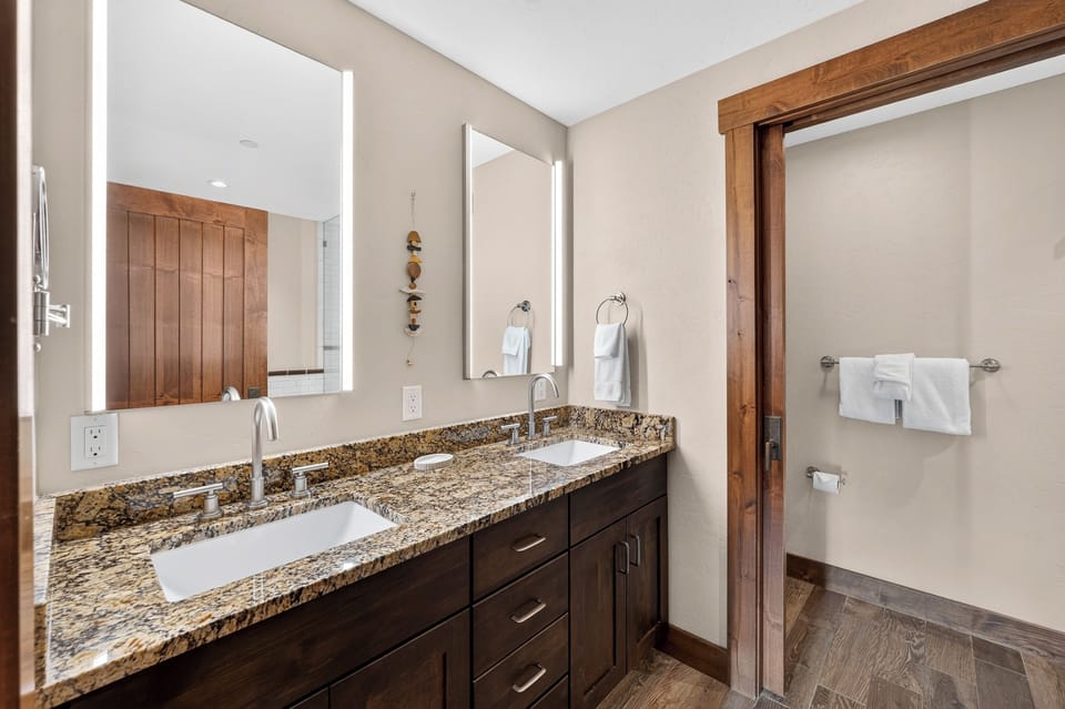 Freshen up at the wood-framed double vanity in the primary's ensuite bath.