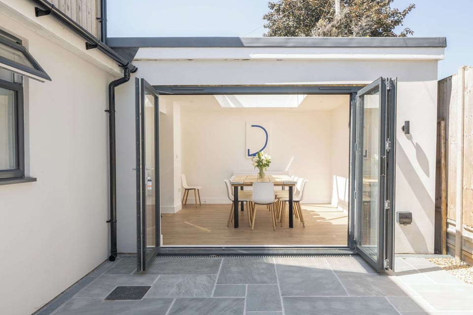 View from the outdoor patio looking directly into the home through wide-open bi-fold doors.