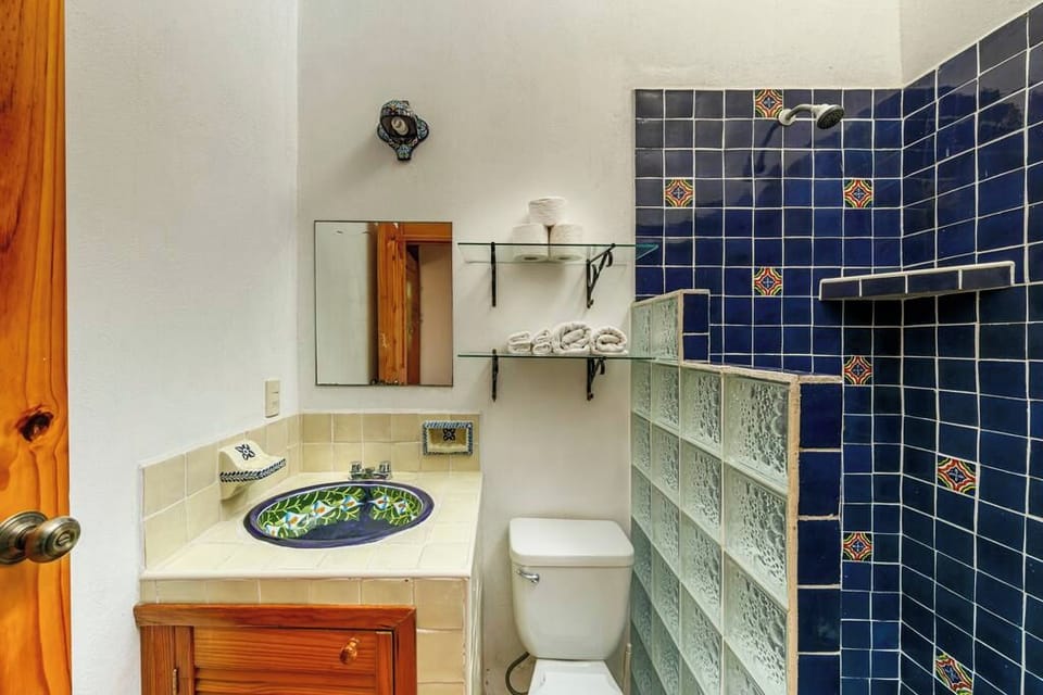 Bathroom with blue tiles and a glass-block shower.