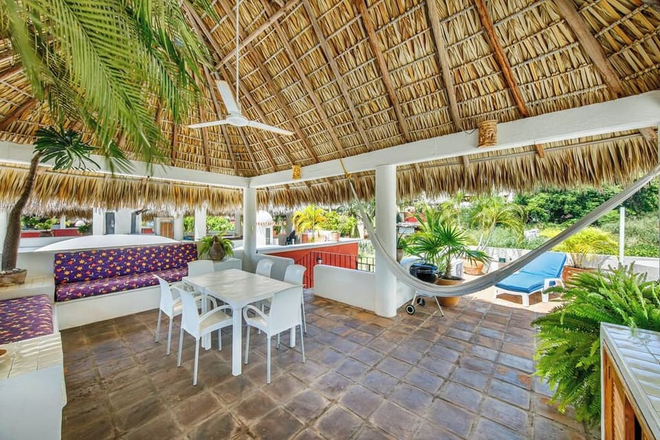 Your rooftop palapa, with a dining table, lounge seating and a hammock.