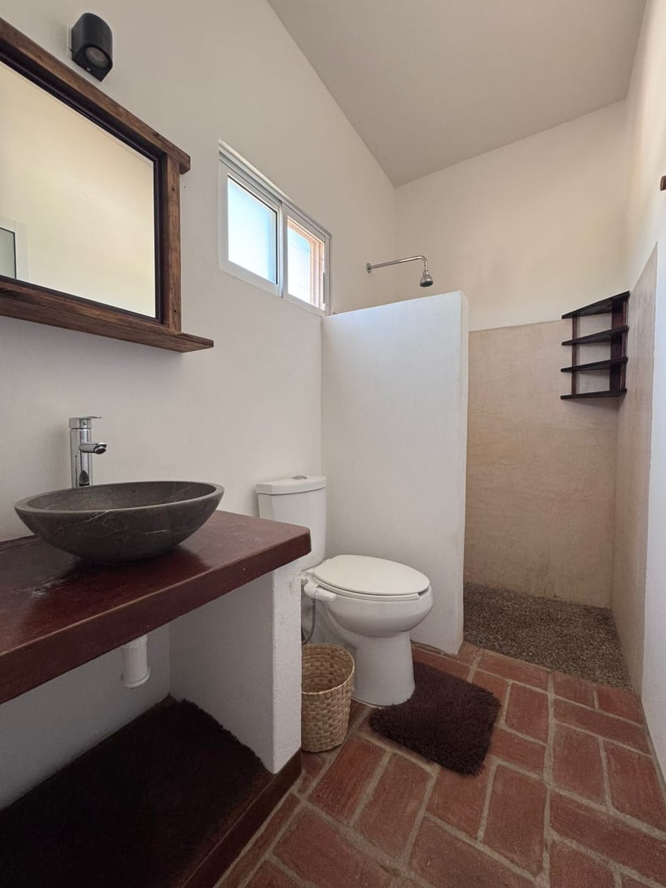 Bathroom with a stone vessel sink and a shower.