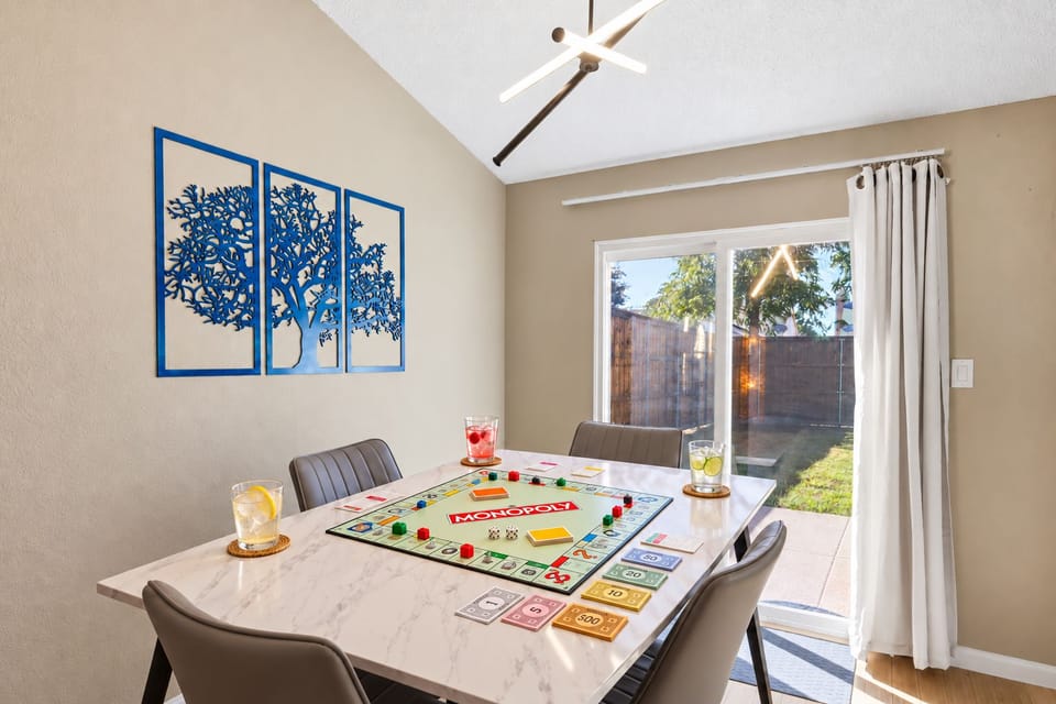 Dining space set up for game night with Monopoly and direct patio access.