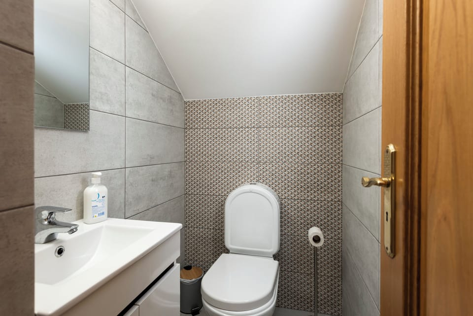 Cozy half-bath with modern fixtures and patterned tile accent