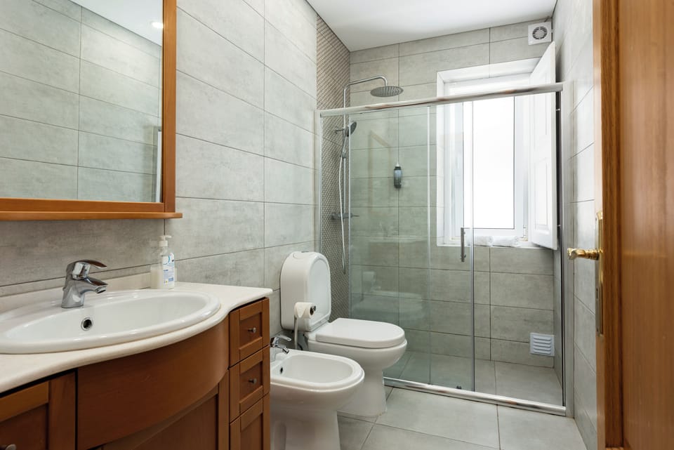 Bright modern bath with walk-in shower, bidet, and roomy vanity.