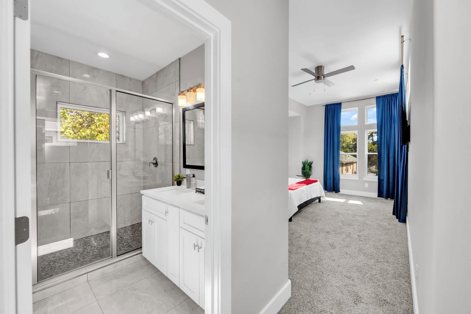 Bright bedroom with en-suite bath and sleek glass walk-in shower