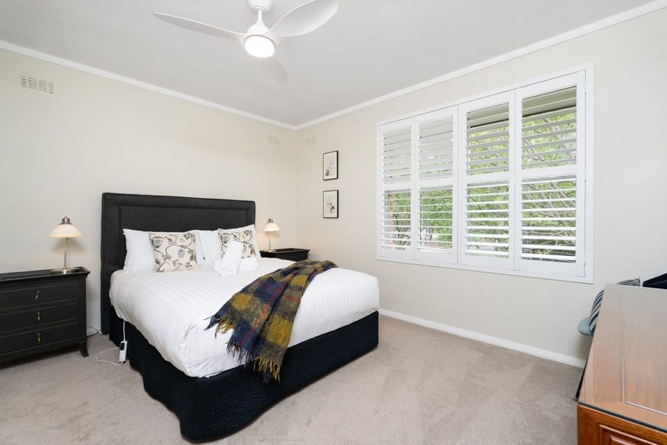 Peaceful bedroom with a comfortable bed, crisp linen and generous windows, offering a bright and restful space to unwind after a day out.