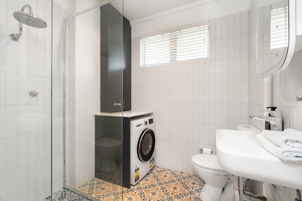 Clean and practical bathroom and laundry area with modern fittings, providing guests with convenient facilities for a comfortable stay.