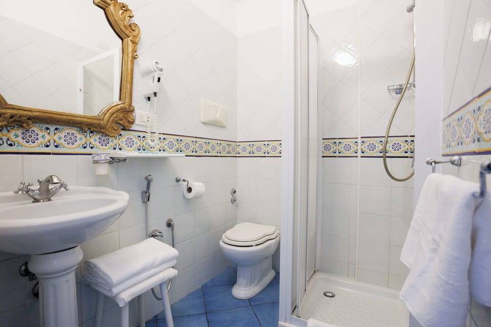 Shower, rainfall showerhead, designer toiletries, hair dryer