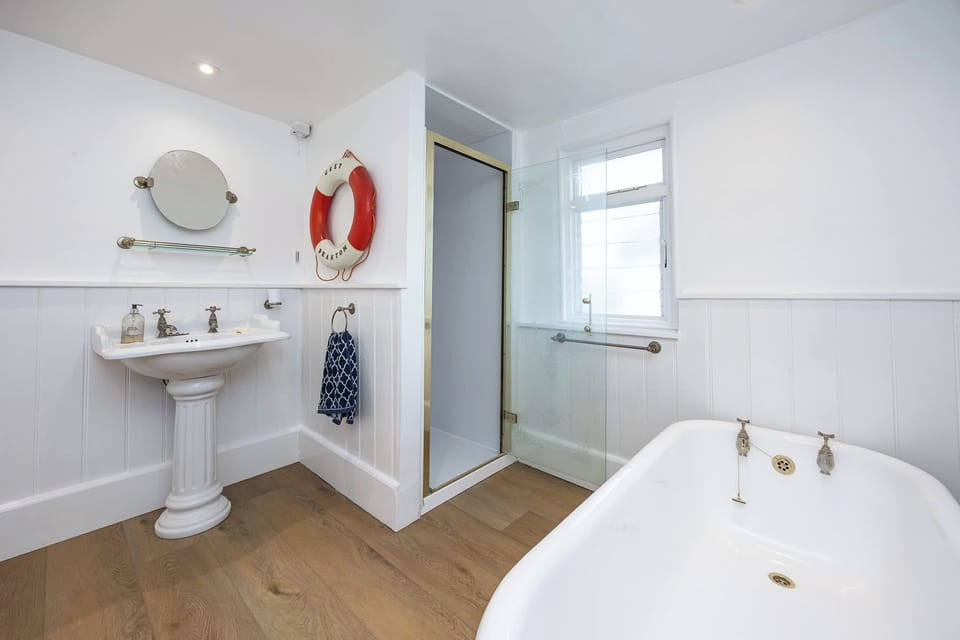 Characterful bathroom with a bath and separate shower. Clean, simple and spacious, with a classic feel and everything needed for a comfortable, easy stay.