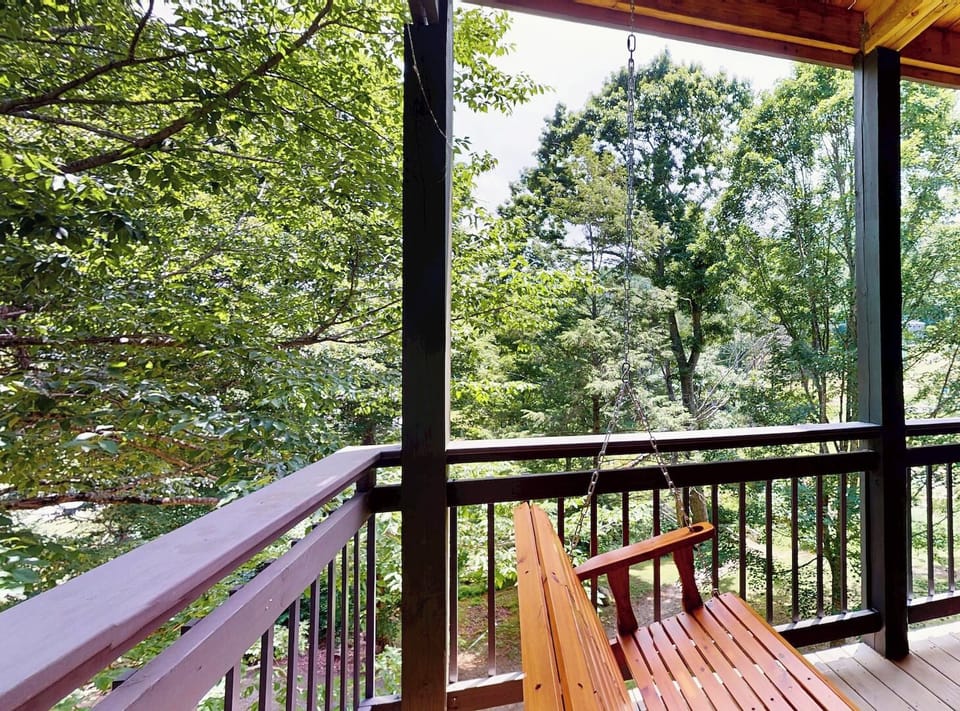 Step onto your private balcony and breathe in the fresh mountain air, surrounded by lush trees and peaceful forest views.