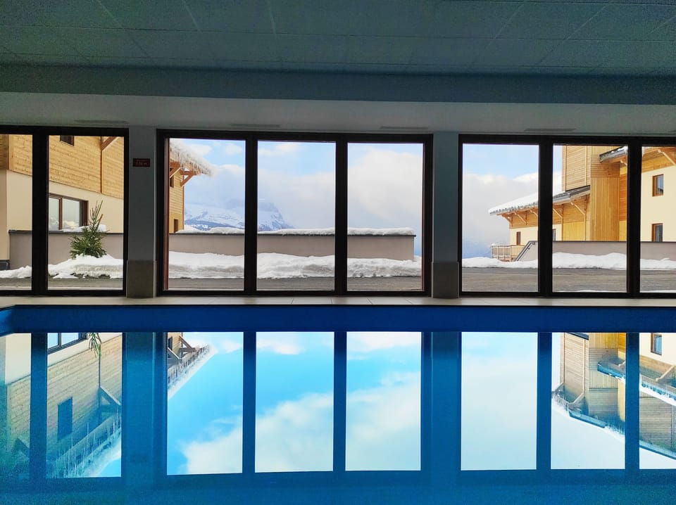 Relax by the heated indoor pool, with large windows showing the mountain views.