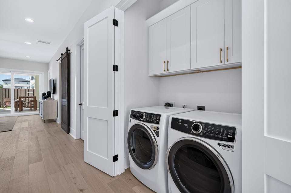 Enjoy the convenience of a first‑floor laundry nook with full‑size washer and dryer, custom cabinetry, and easy access for pool towels, beach gear, and multi‑family stays.