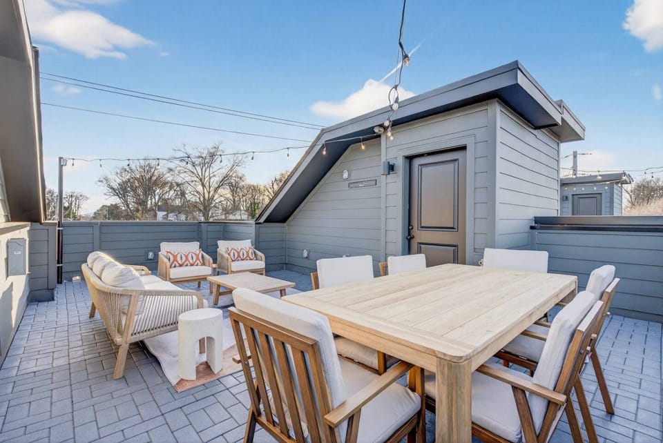 Private rooftop with comfortable outdoor furniture, a dining table and string lights —perfect for relaxing or entertaining.