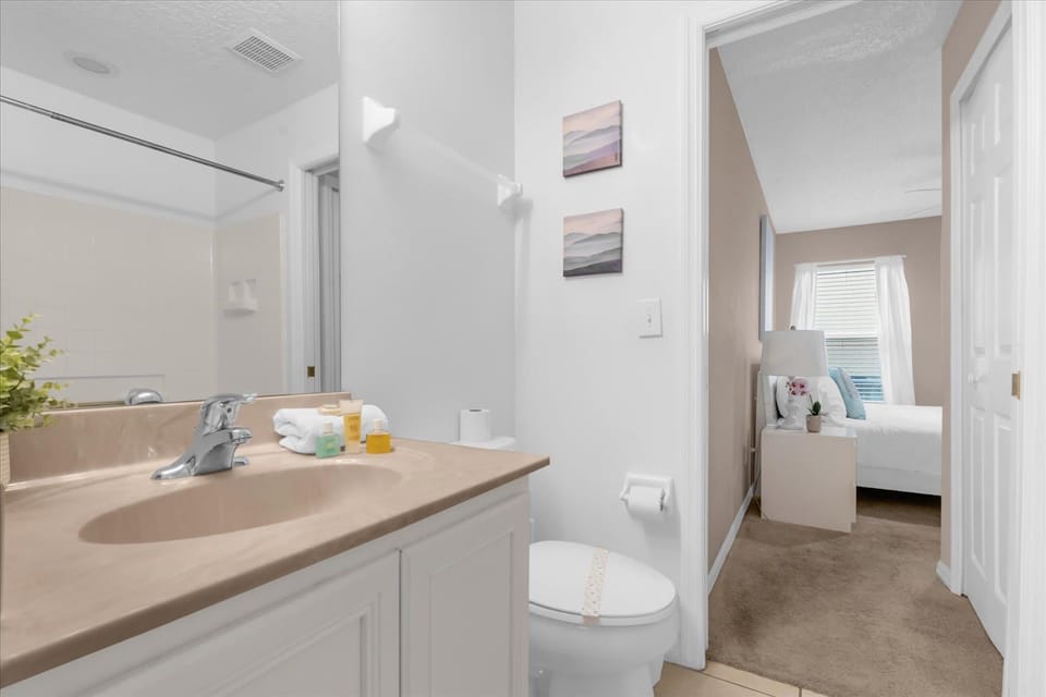 A pristine bathroom sink vanity stocked with freshly rolled bath towels