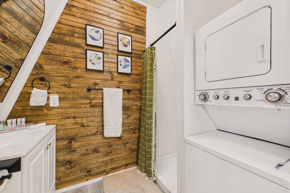 Well-appointed bathroom featuring rustic wood accents and in-unit laundry for added convenience.