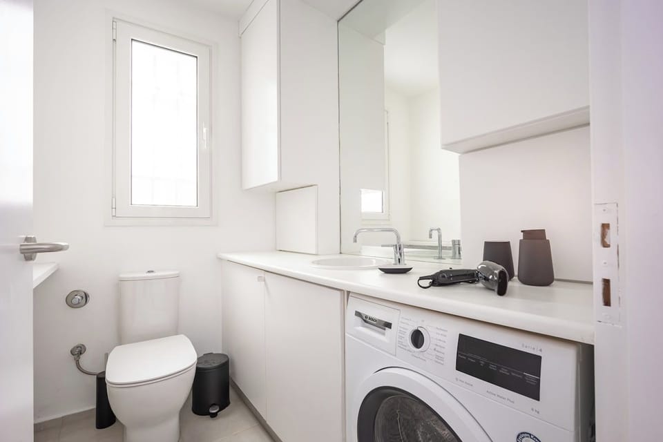 White bathroom with washing machine.