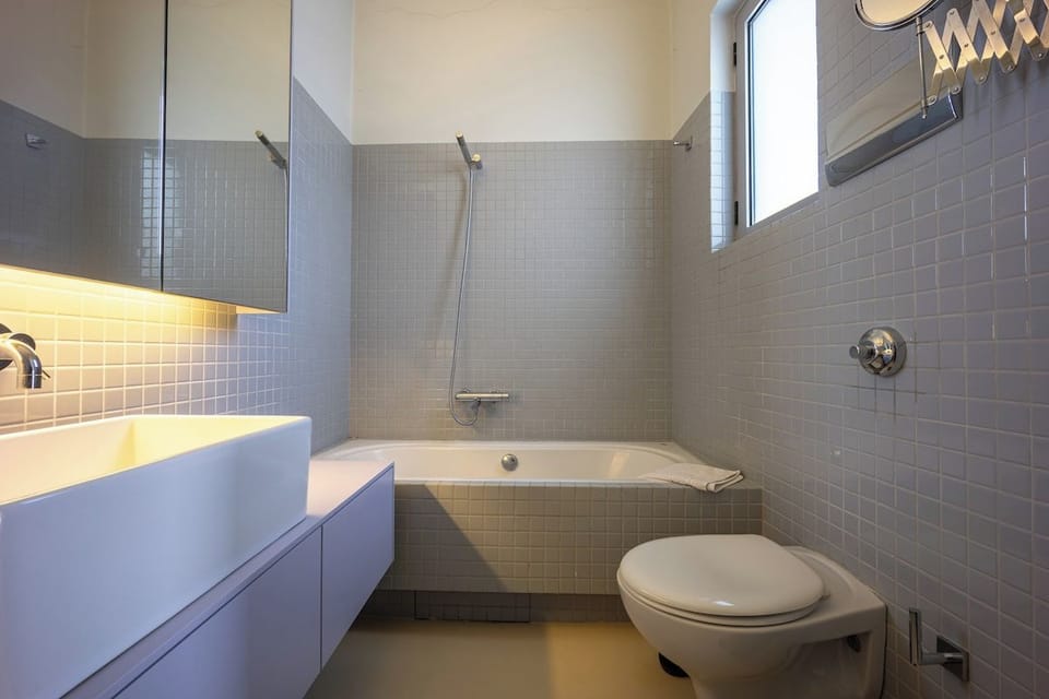 Deep bathtub framed in grey tile.