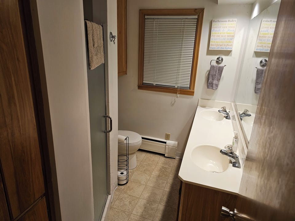 Bathroom with 2 sinks, shower, and toilet