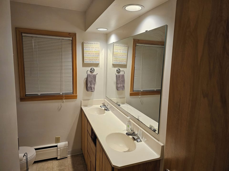 Bathroom with 2 sinks, shower, and toilet