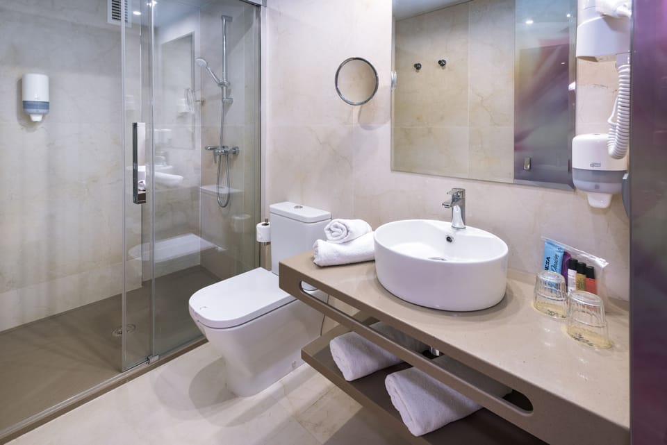 Shower, designer toiletries, hair dryer, towels