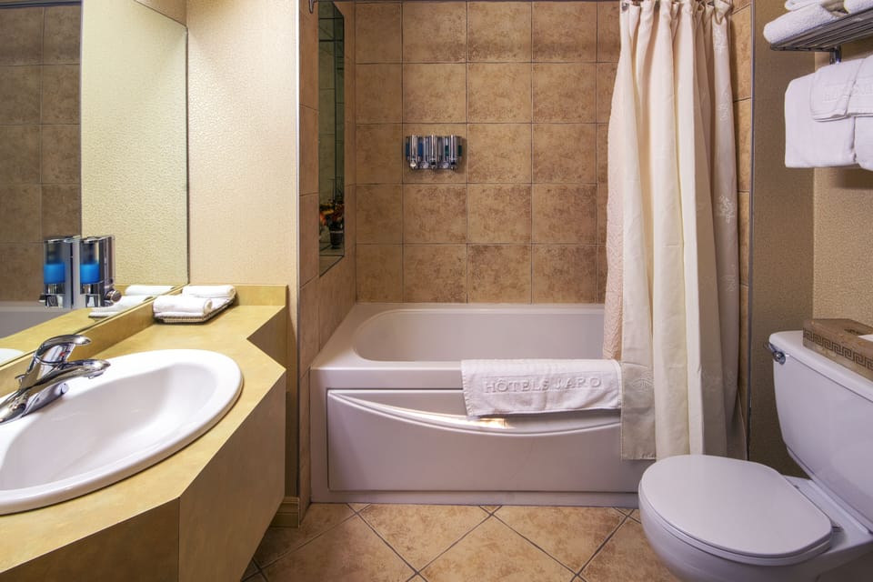 Economy Room, 1 Queen bed and single whirlpool bath | Bathroom | Combined shower/tub, hair dryer, towels