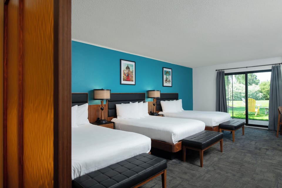 Deluxe Triple Room, Multiple Beds, Refrigerator & Microwave, Courtyard View | Desk, laptop workspace, blackout drapes, iron/ironing board