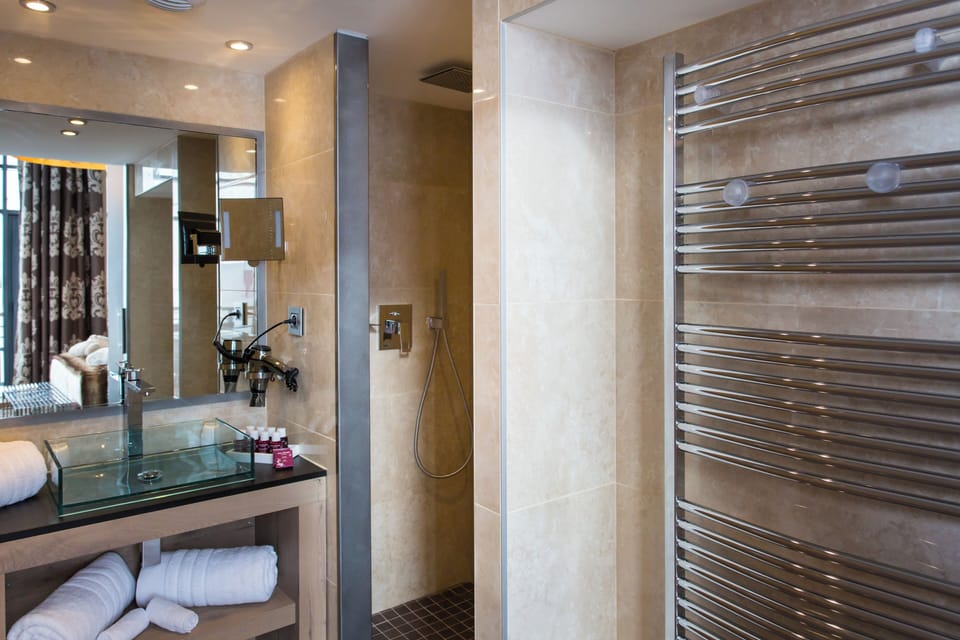 Bathtub, designer toiletries, hair dryer, bathrobes