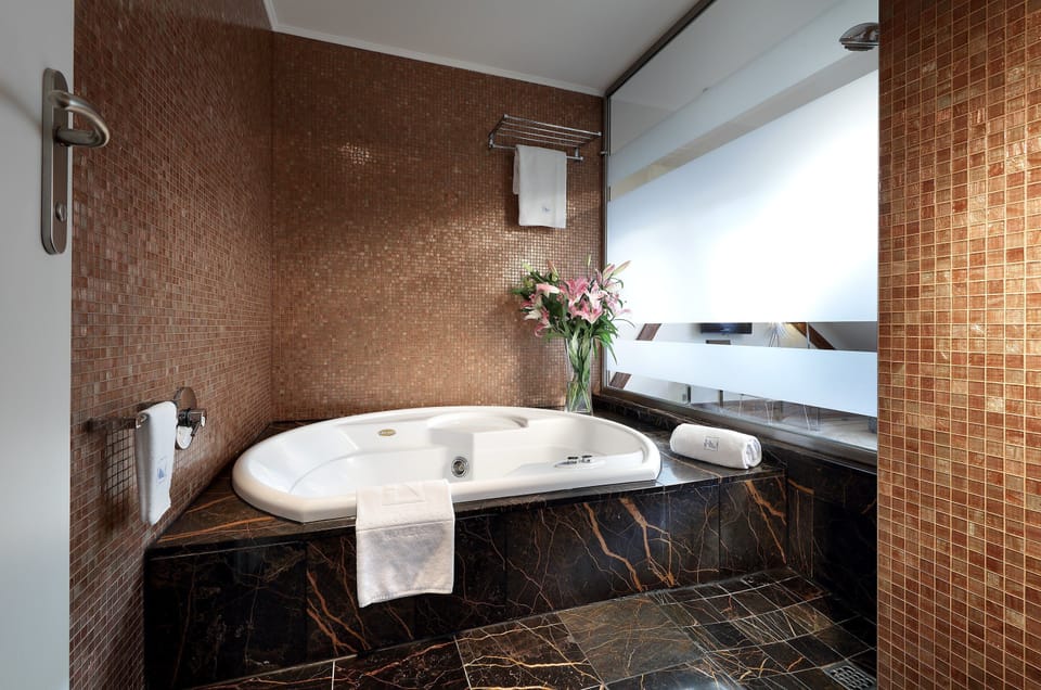 Deluxe Double Room | Bathroom | Rainfall showerhead, designer toiletries, hair dryer, slippers