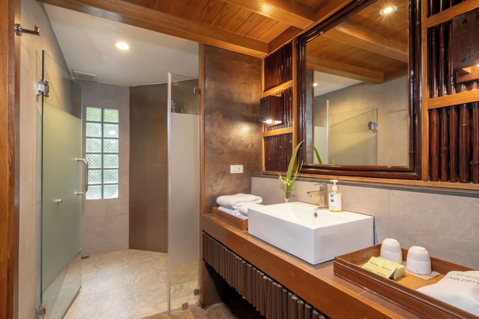 Deluxe Room, River View | Bathroom | Designer toiletries, hair dryer, slippers, towels