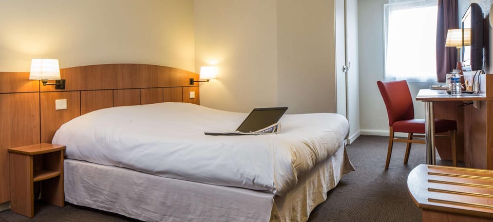 Premium bedding, desk, laptop workspace, blackout drapes