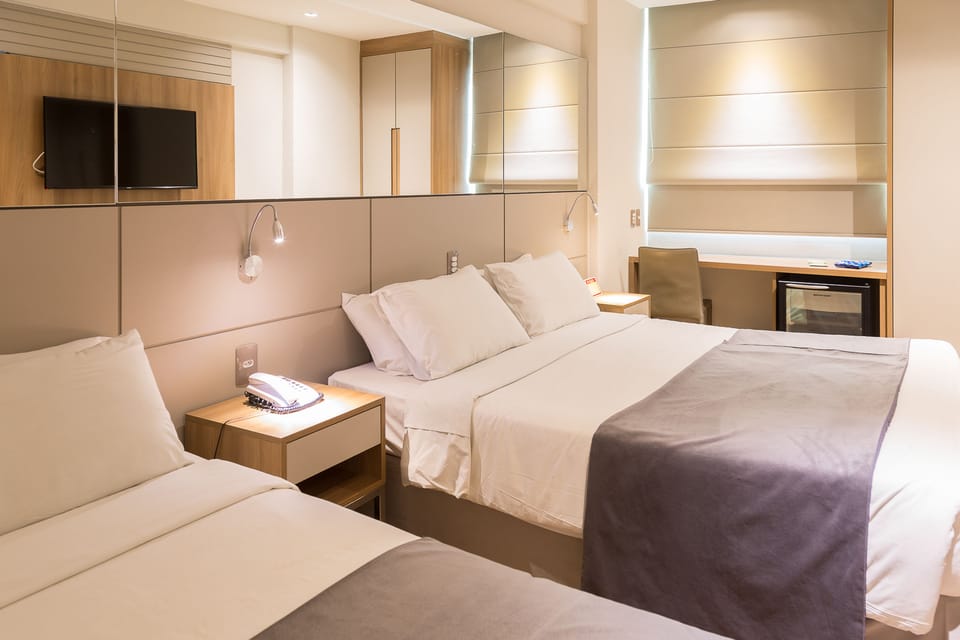 Deluxe Triple Room | Minibar, in-room safe, desk, blackout drapes