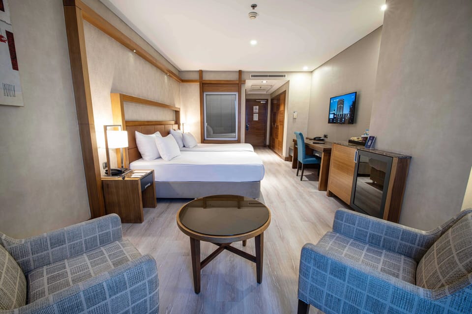 Deluxe Room | Minibar, in-room safe, desk, iron/ironing board