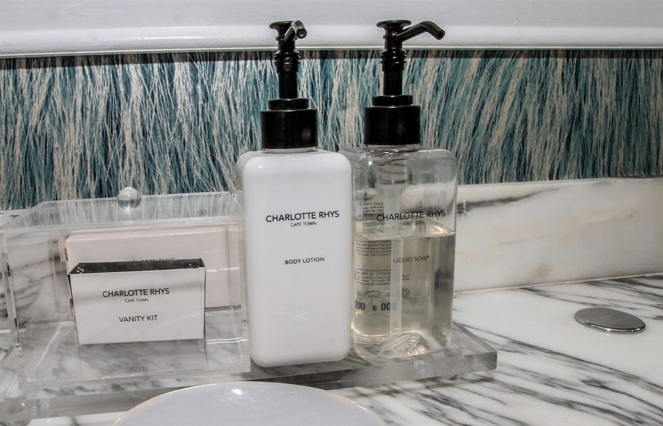 Designer toiletries, hair dryer, slippers, towels