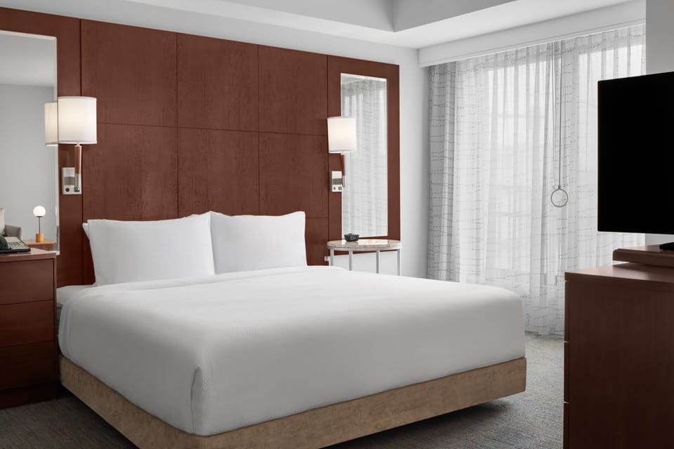 Premium bedding, desk, laptop workspace, blackout drapes