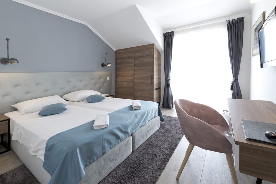 Double or Twin Room, Partial Sea View | Minibar, in-room safe, desk, blackout drapes