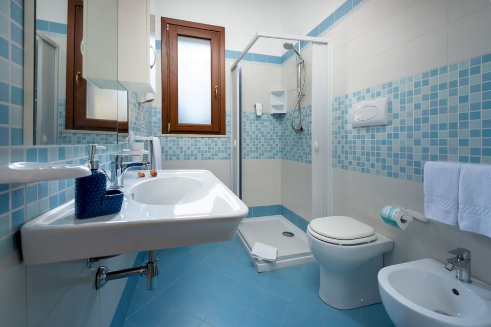 Double Room, Patio (Rosa Blu) | Bathroom | Shower, rainfall showerhead, free toiletries, hair dryer