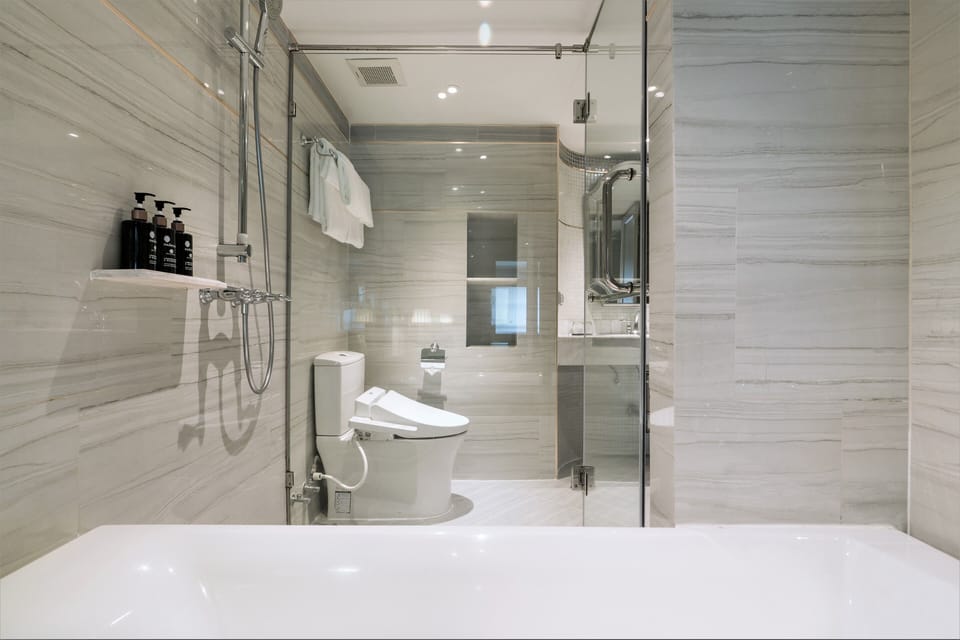 The Living Suite | Bathroom | Designer toiletries, hair dryer, bathrobes, slippers
