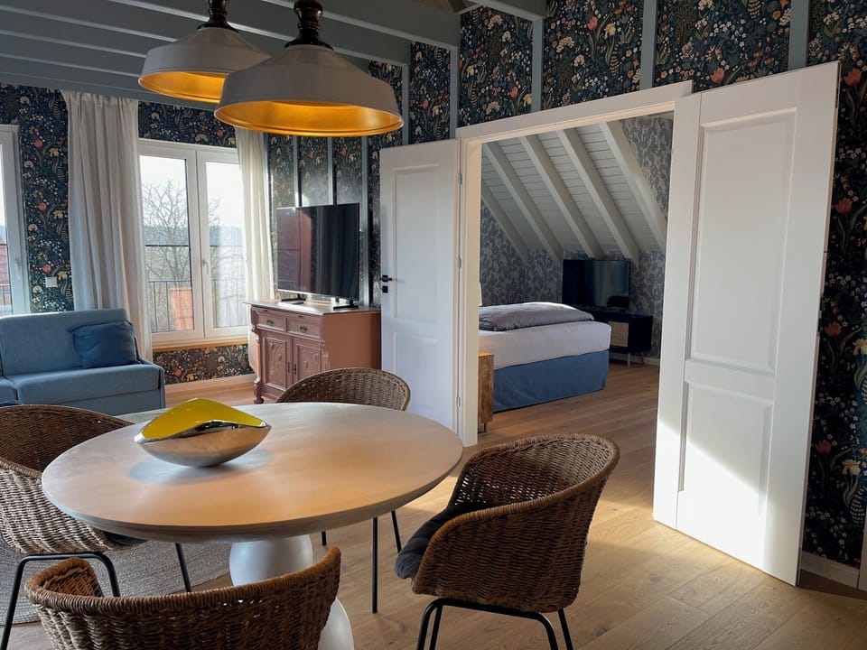 Deluxe Suite | Living area | 50-inch flat-screen TV with satellite channels, TV, heated floors