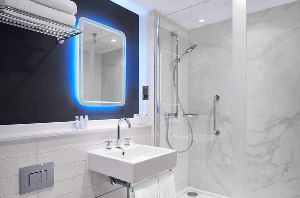 Shower, designer toiletries, hair dryer, towels