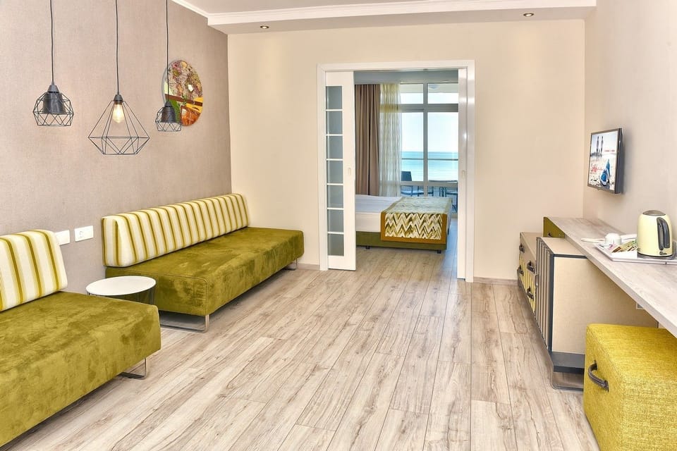 Family Room with Sea View - Free Infinity Pool and Private Beach Access | Living area | Flat-screen TV, books