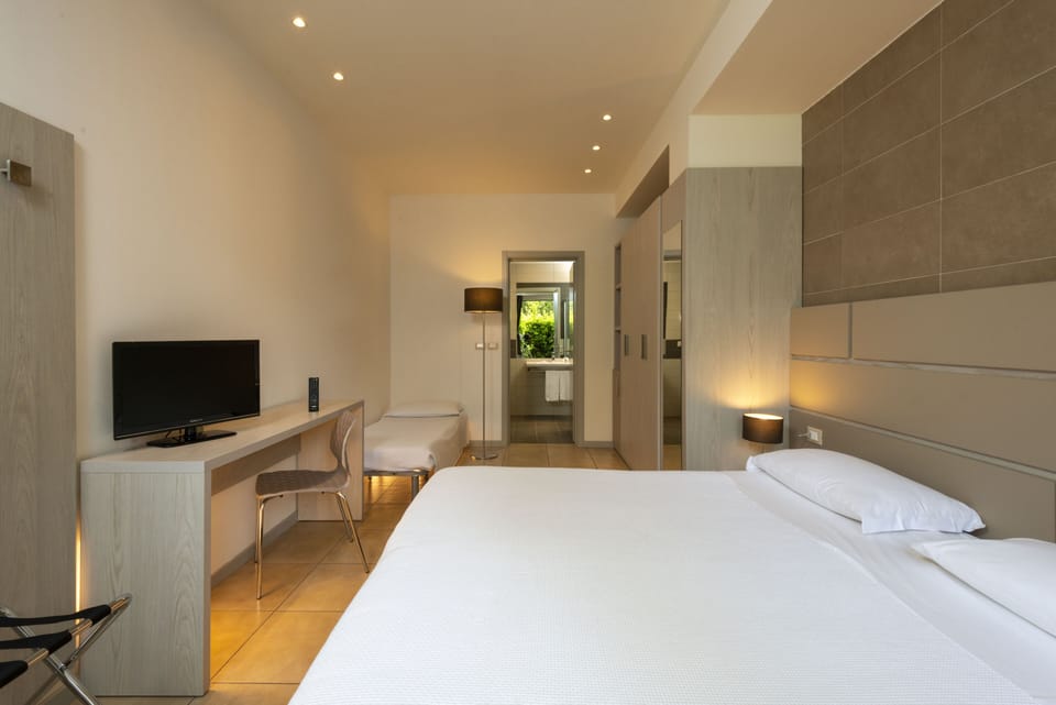 Superior Triple Room | Minibar, in-room safe, desk, blackout drapes