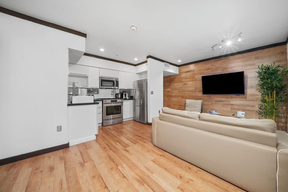 Deluxe One Bedroom King Suite | Living area | 42-inch plasma TV with cable channels, TV, iPod dock
