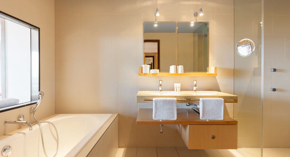 Deluxe Suite, Sea View | Bathroom | Rainfall showerhead, free toiletries, hair dryer, bathrobes
