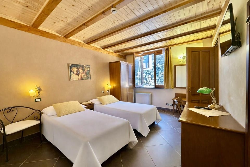 Quadrupla con camere matrimoniali comunicanti | Minibar, in-room safe, desk, iron/ironing board