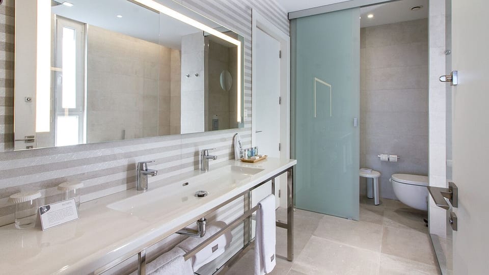 Designer toiletries, hair dryer, slippers, towels