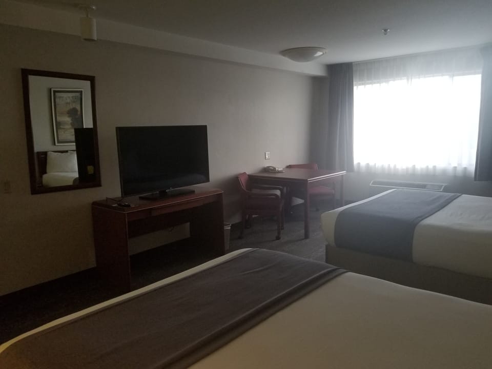 Suite, 2 Queen Beds | Living area | 42-inch LCD TV with cable channels, pay movies