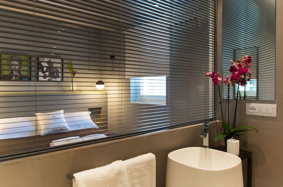 Deluxe Suite with Exposed Bathroom | Bathroom | Shower, designer toiletries, hair dryer, slippers