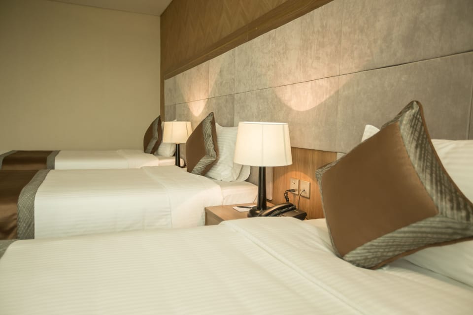 Deluxe Triple Room | Minibar, in-room safe, desk, blackout drapes