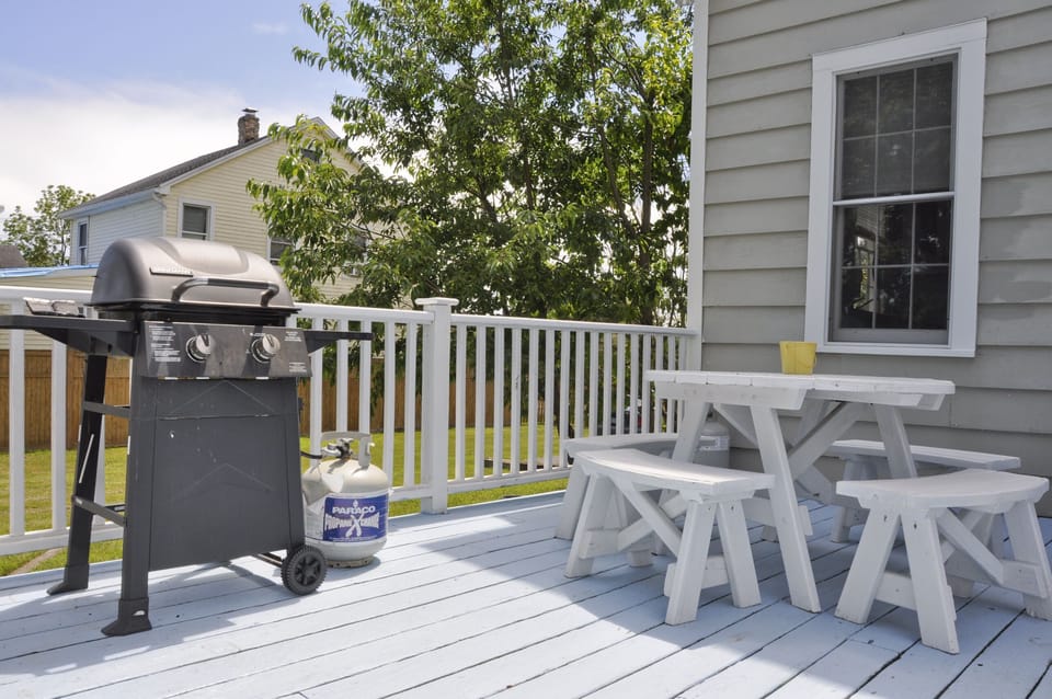 Gas grill, one of two picnic tables on back deck